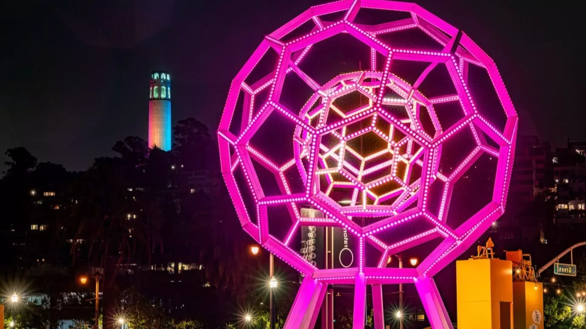 Buckyball leuchtet vor dem Exploratorium, im Hintergrund der Coit Tower