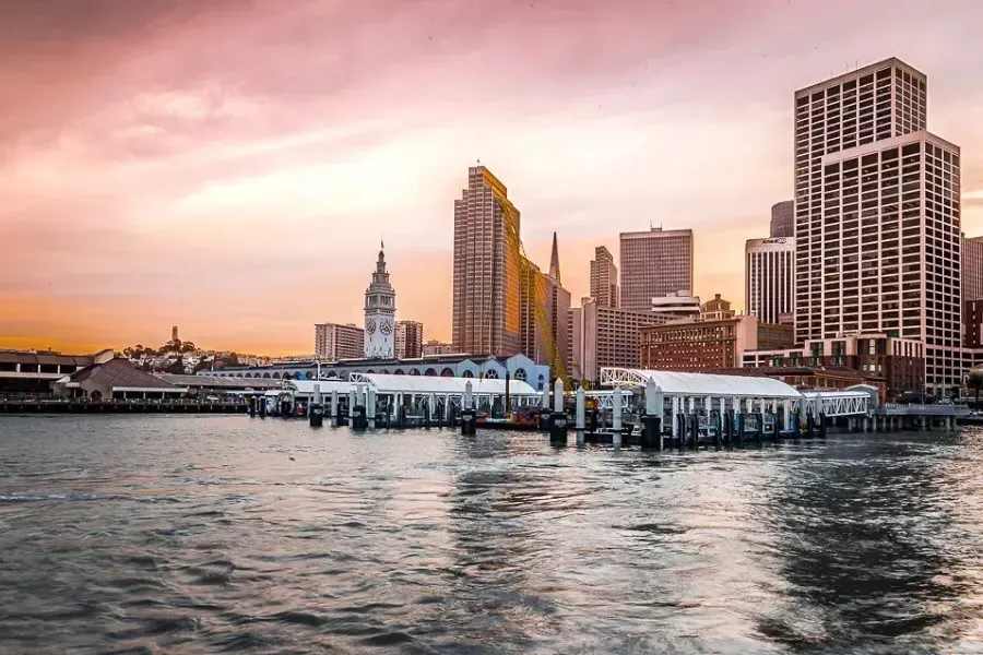 O Ferry Building ao pôr do sol visto da baía.